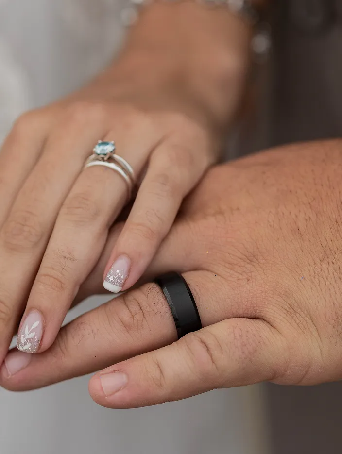 Two hands of couple with engagement rings