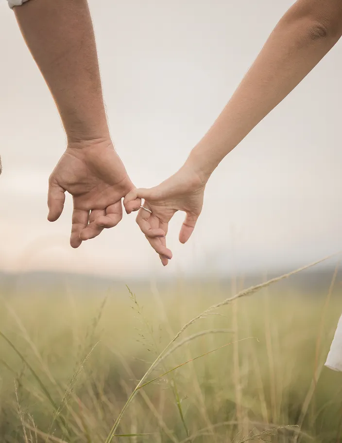 Couple Holding hands while in a field