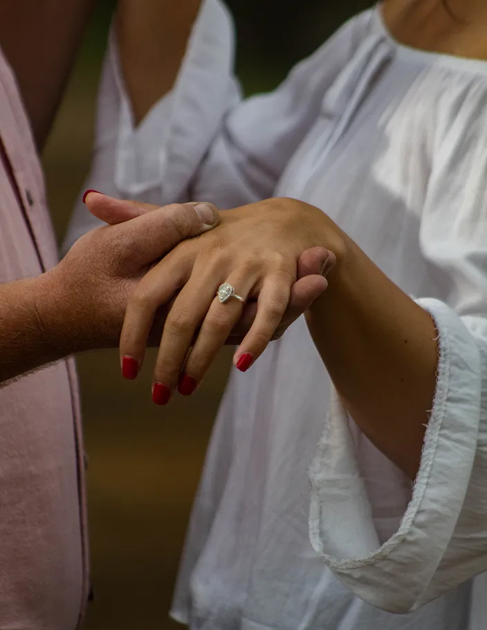 Couple holding hands showing engagement rings