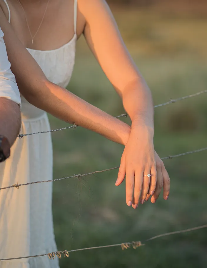 A couple over barbed wire.