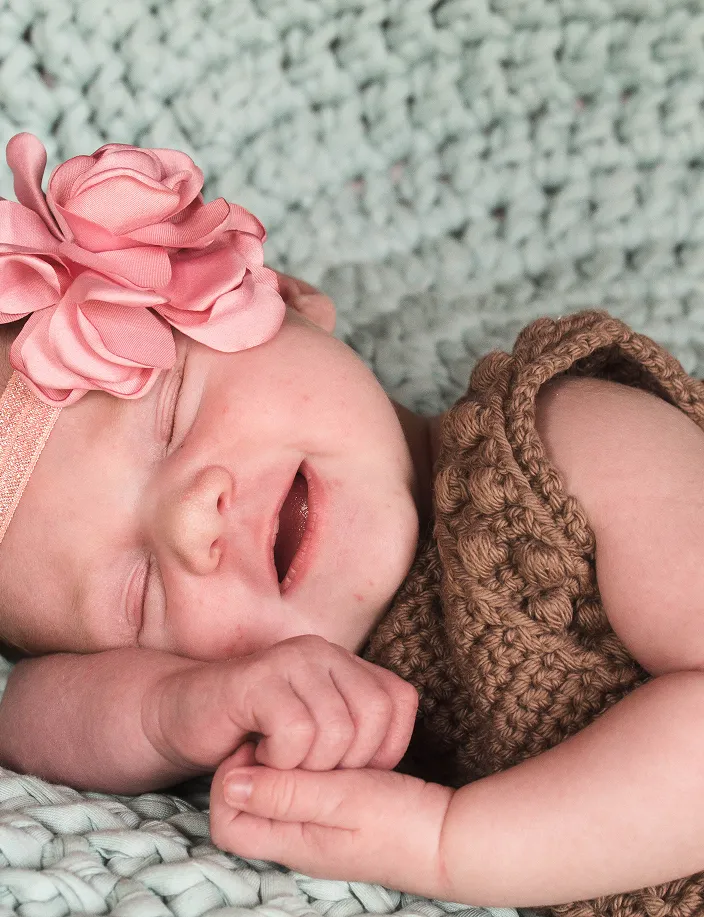 Sleeping newborn smiling