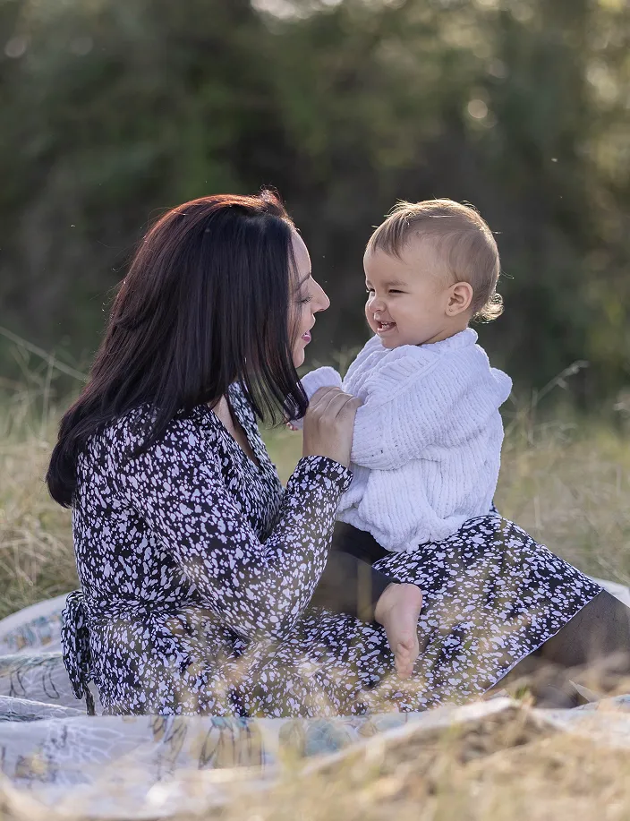 Mother playing with newborn on lap