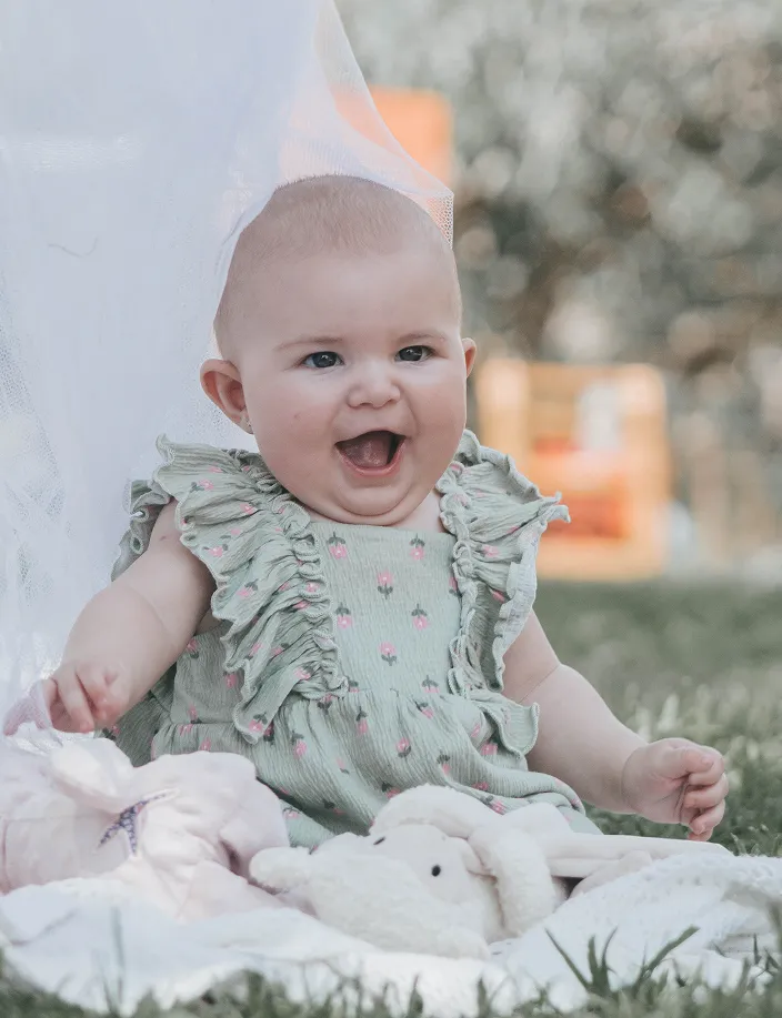 Newborn smiling sitting on grass