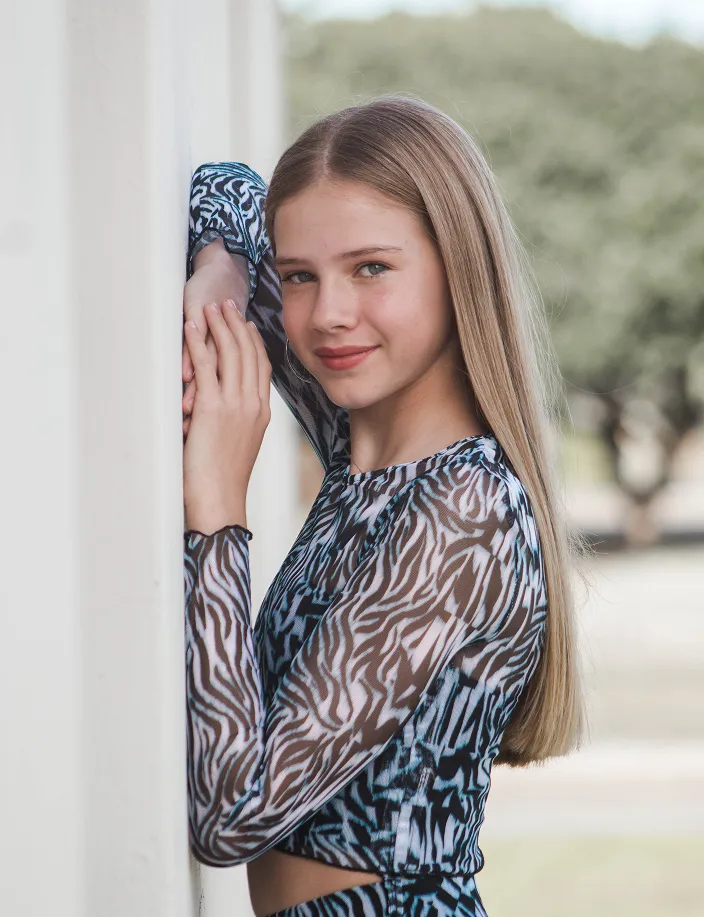 Young woman with arms on wall in portrait