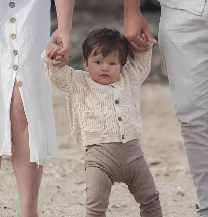 Newborn holding the hands of their family members
