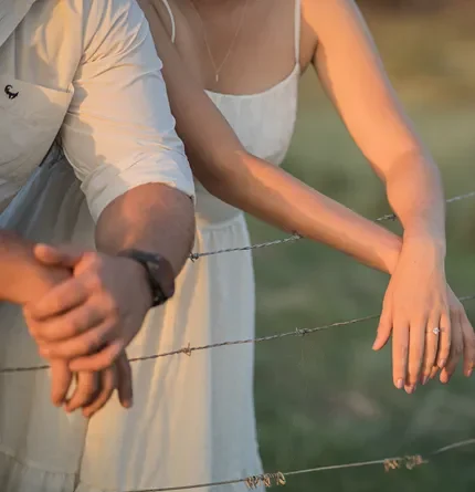 A couple over barbed wire.