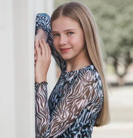 Young woman with arms on wall in portrait