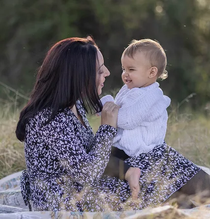 Mother playing with newborn on lap